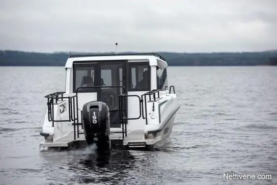 A white boat with an outboard motor, gliding over calm waters under a cloudy sky, viewed from the rear.